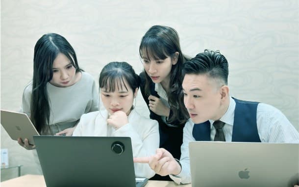 An atmospheric photo of Japanese and Vietnamese members discussing deal strategy around a whiteboard